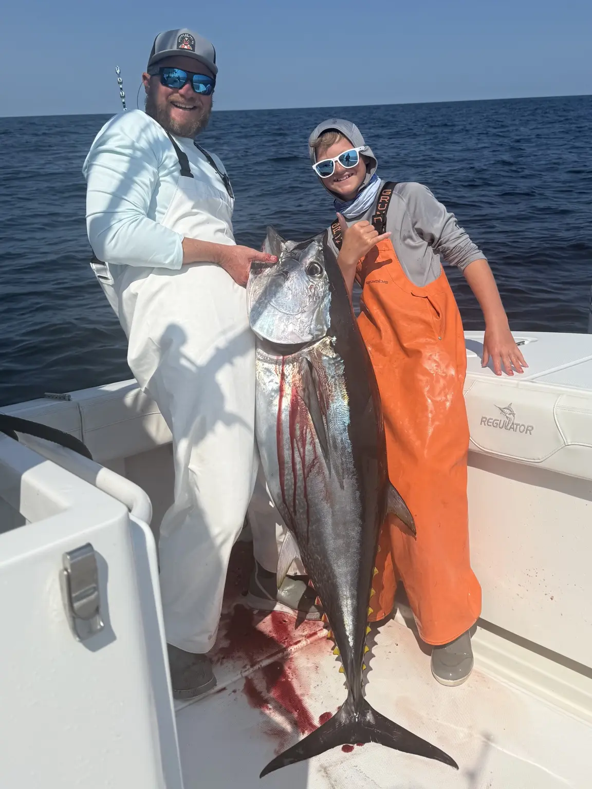 Adult and young angler displaying a bluefin tuna offshore