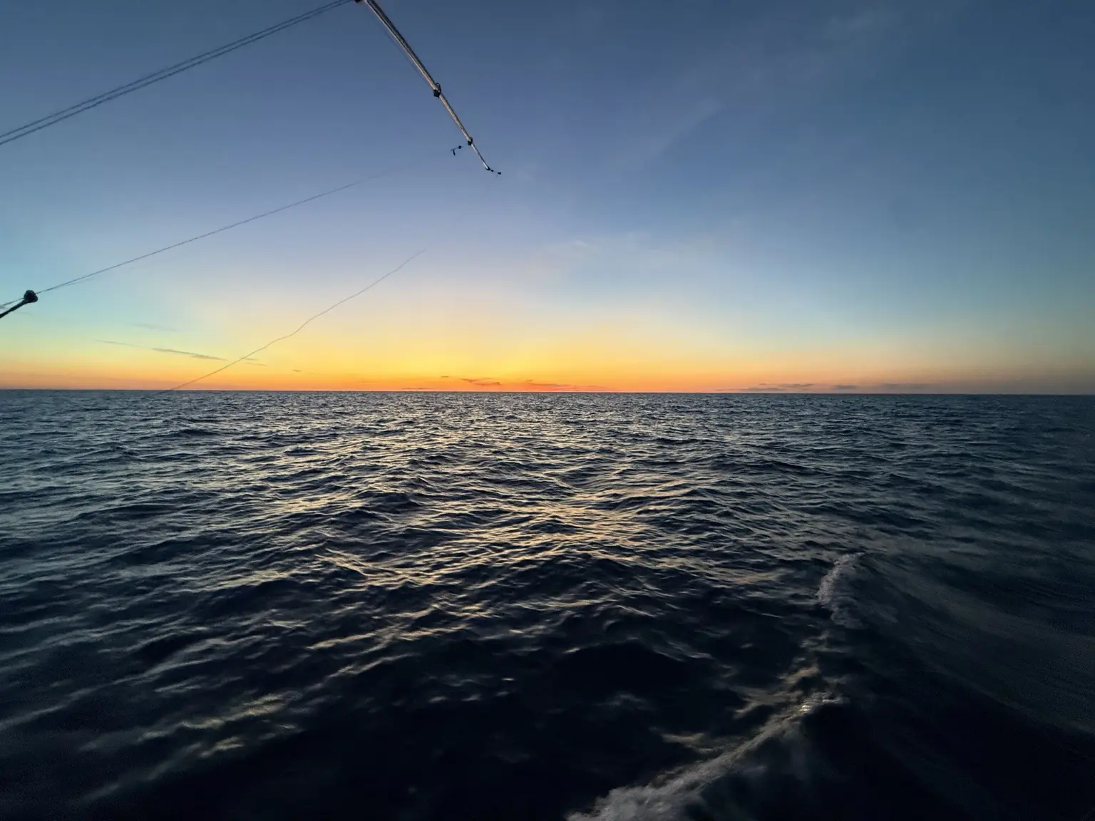 Sunset over the open ocean during a canyon fishing trip