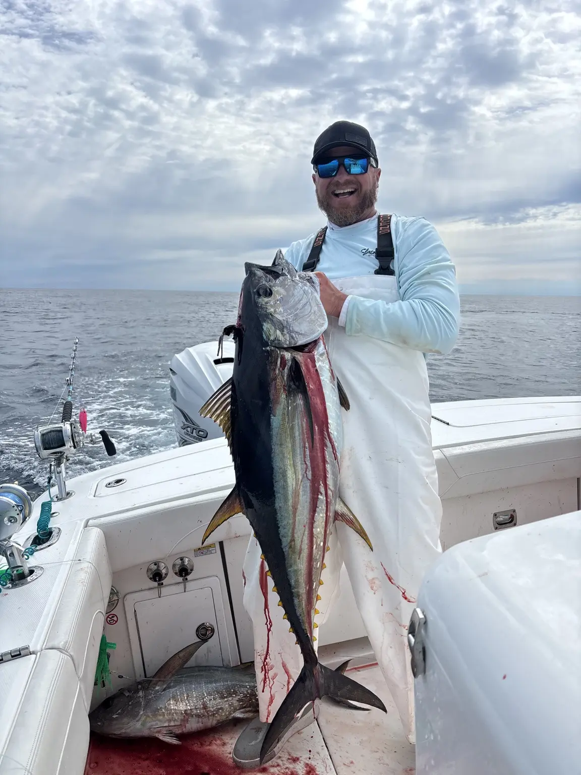 Slack Tide angler holding a tuna aboard the boat offshore from Rhode Island